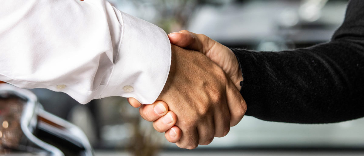 Terminalenmedarbejder giver hånd til kunde 