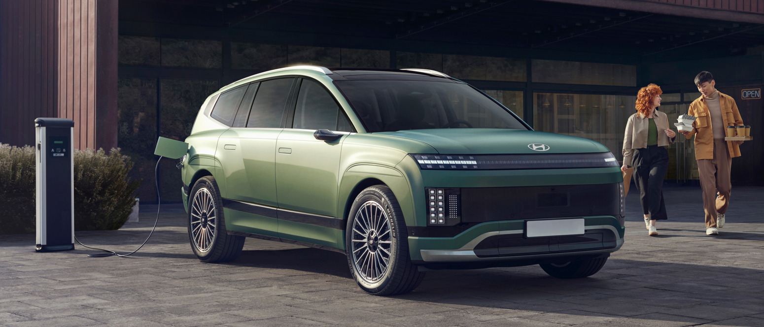 IONIQ 9 holder og oplader mens mand og kvinde henter kaffe og mad