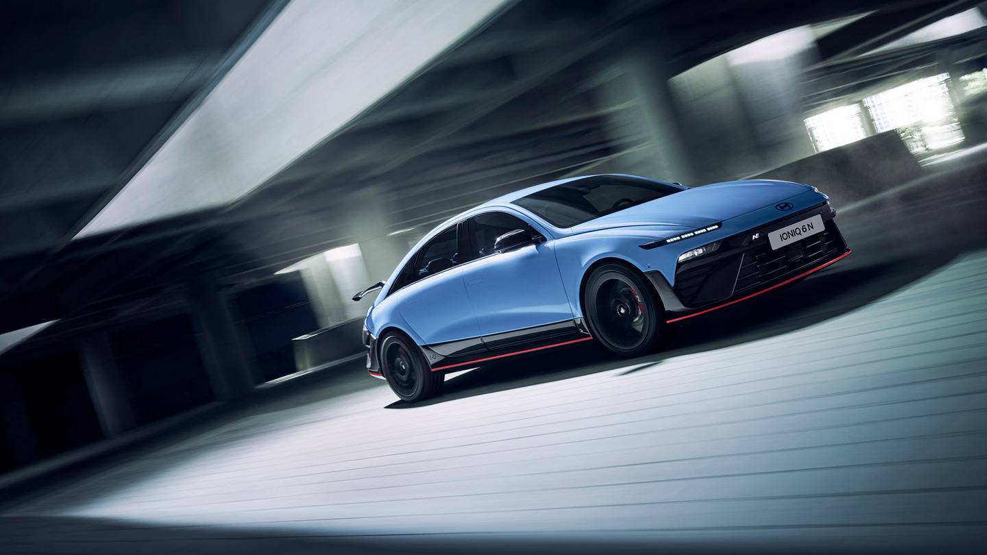 En blå Hyundai Ioniq 6 N elbil kører gennem et moderne parkeringshus i flere niveauer og indfanger følelsen af dynamisk bevægelse.