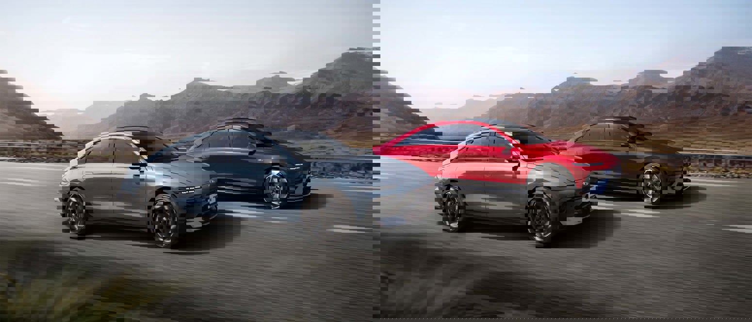 Et forvrænget billede af tre biler, der kører på en vej med bjerge i baggrunden.